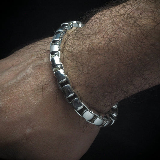A round box bracelet with thick links on a model's wrist.