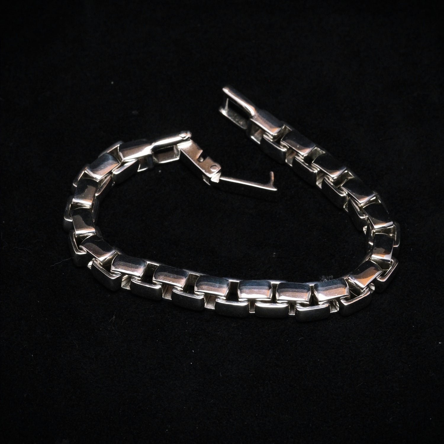 Silver chain bracelet on a black background